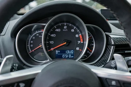 Compteur de vitesse d'une voiture de sport affichant 290 km/h, tableau de bord en fibre de carbone, photo réaliste illustrant la vitesse excessive et le danger sur route