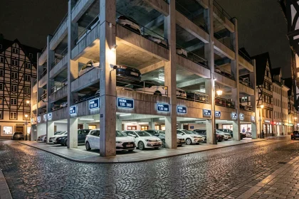 Parking centre-ville de Colmar de nuit avec signalétique tarifaire et façade sécurisée